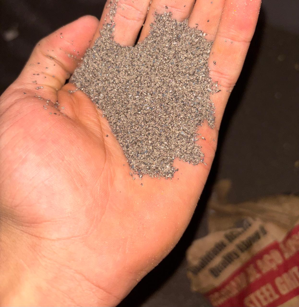 Granalha de aço na mão, abrasivo usado no jateamento industrial